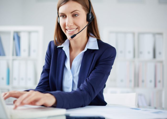 Young businesswoman with headset consulting clients online